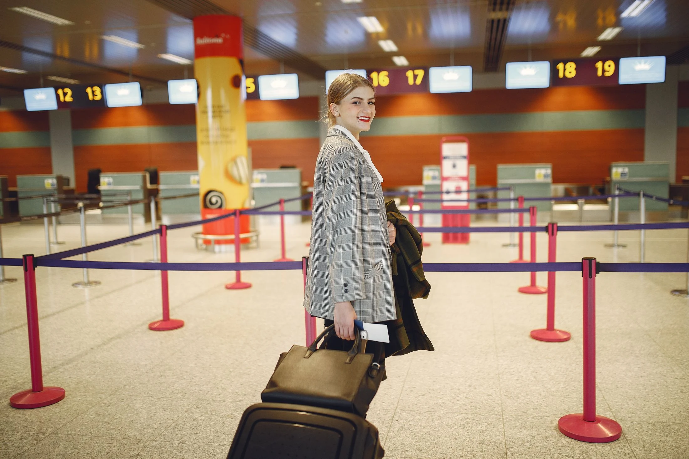 Business traveller walking with luggage through an airport check-in area