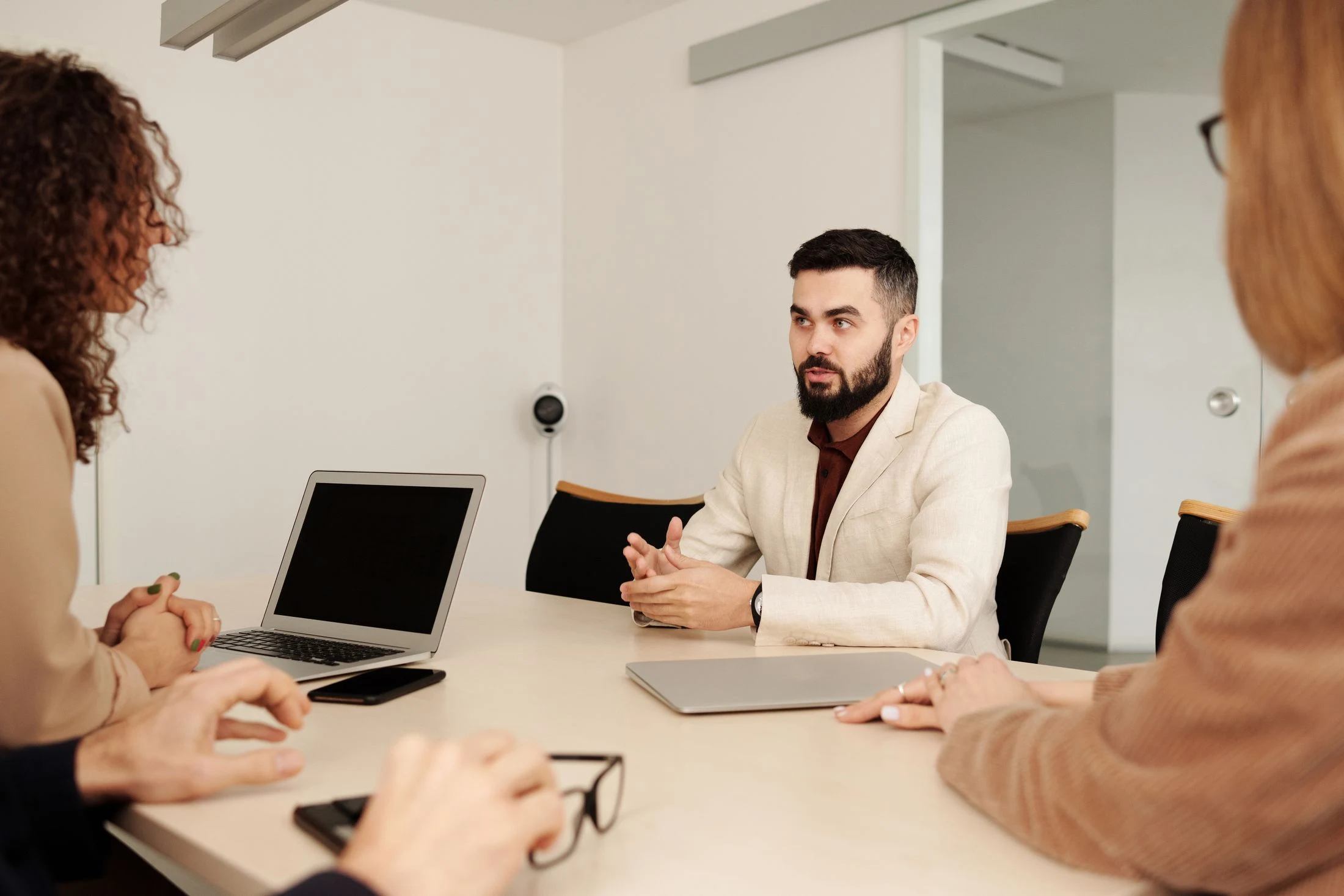Business professionals discussing plans around a laptop in an office